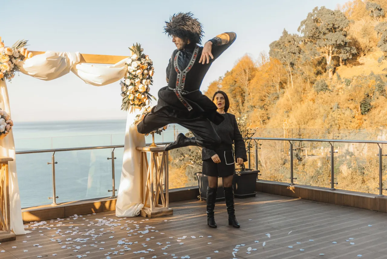 Georgian dancer mid-jump on a terrace above the sea