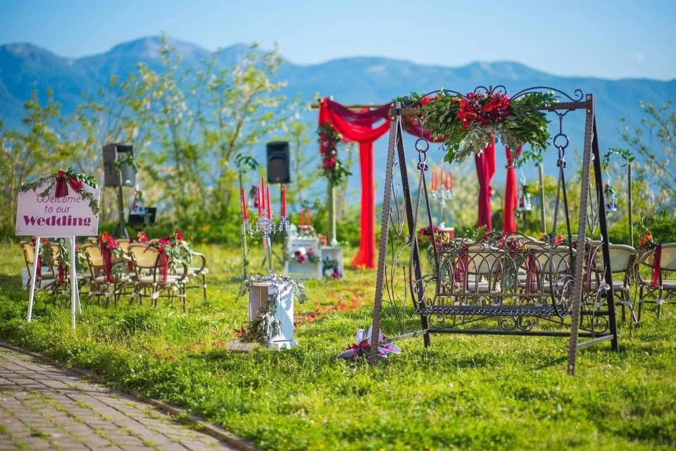 Ceremony setting with red decor and a swing on a mountain clearing