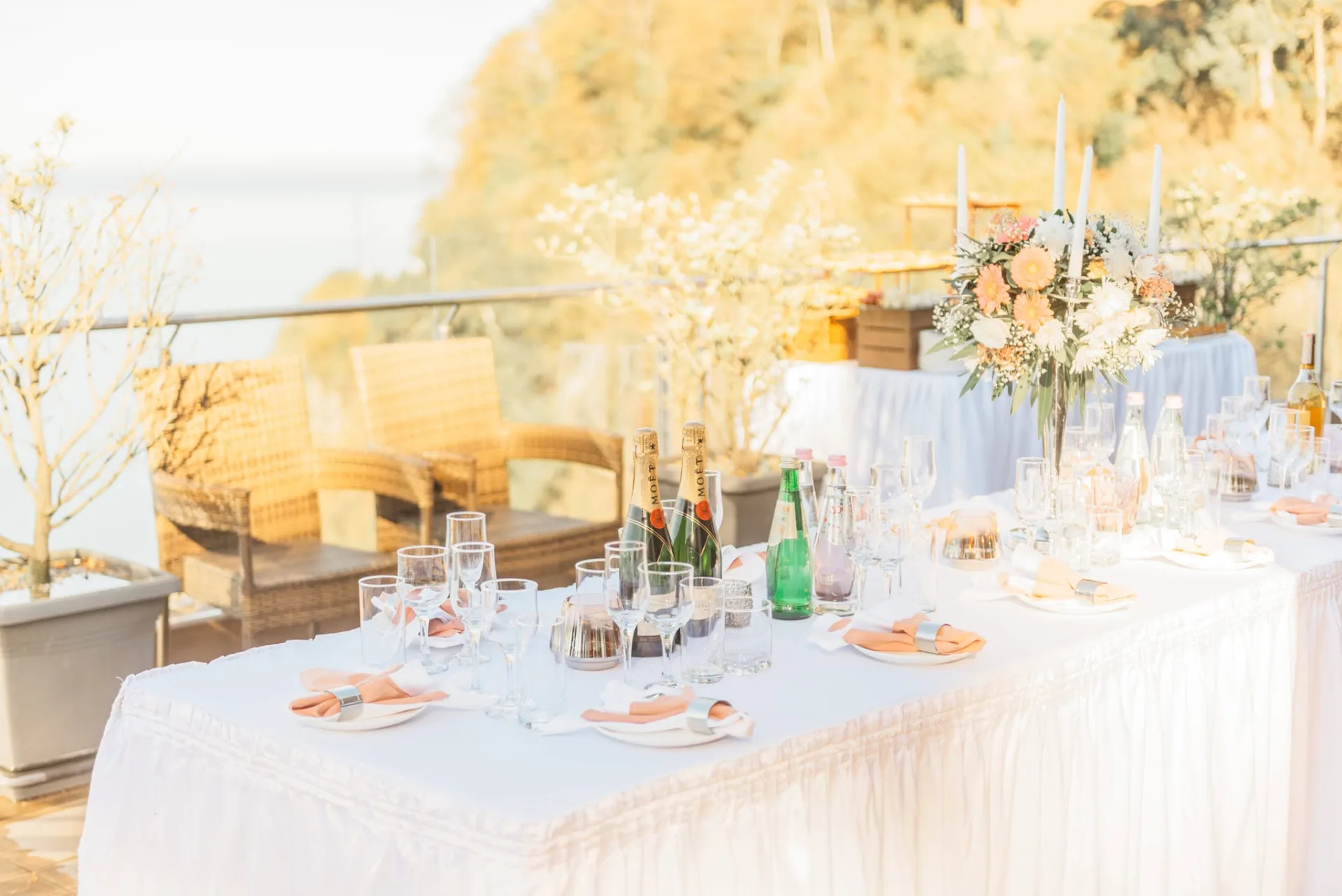 White banquet table above a sea cliff in the golden evening light