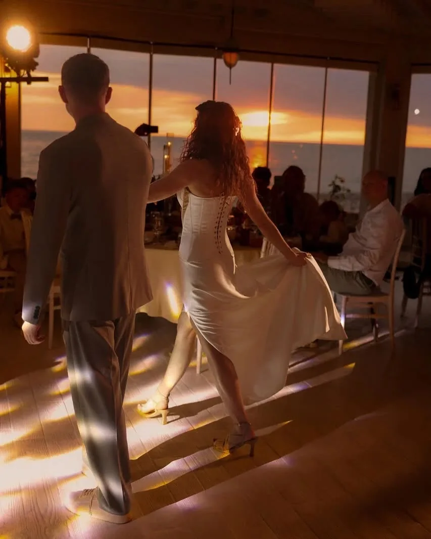 First dance in the hall at sunset, the couple in silhouette on a lit floor