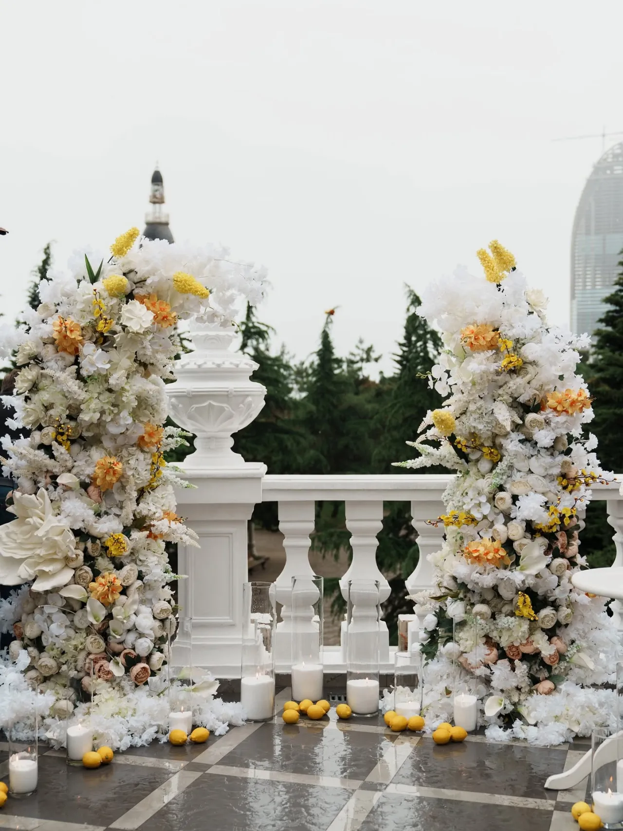 Ceremony area with white flower columns and lemons on a chequered terrace in Batumi